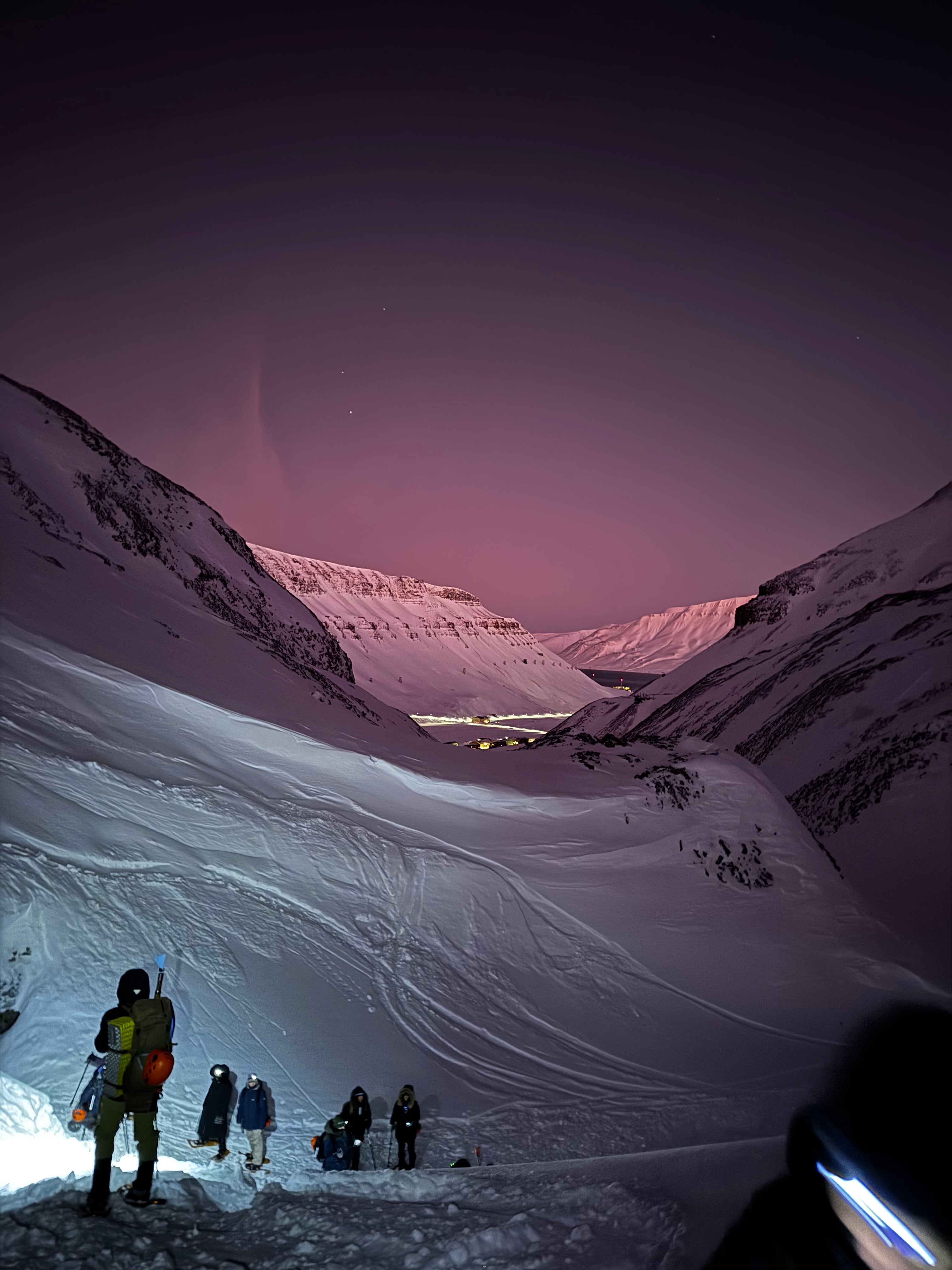 Hikers walking through a snowy mountain valley during an outdoor adventure
